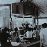 This 1977 photograph shows famed naturalist Ross Allen giving a lecture on alligators to visitors in the new roofed theater.
