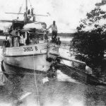 Three hundred miles up the Fly River on a reptile hunting expedition, George Craig and his helpers pause at a makeshift landing.